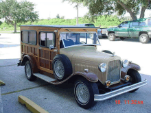 a woody station wagon is parked in a parking lot