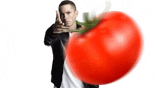 a man is pointing at a large tomato