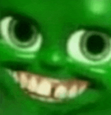 a close up of a green cartoon character 's face with a big smile .