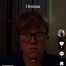 a man wearing glasses says " i know " in the corner of his face