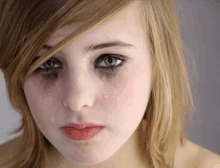 a close up of a girl 's face with tears running down her face