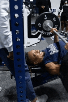 a man is lifting a barbell with the letter j on the barbell