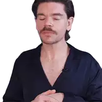 a man with a beard and mustache wearing a blue shirt with his eyes closed