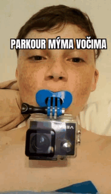 a young boy with a camera attached to his mouth and the words parkour myma vocima above him