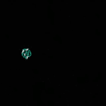 a glowing green cube is floating in the dark .