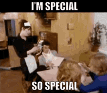 a group of people are sitting at a table with a waiter standing behind them and the caption says i 'm special