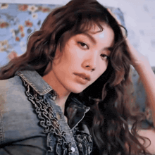 a woman with long hair wearing a denim jacket