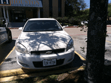 a white car is parked in front of the houston housing authority building