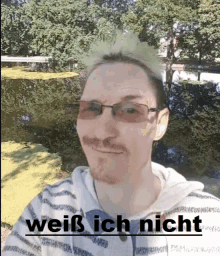 a man wearing glasses and a striped shirt with the words " weiß ich nicht " on the bottom