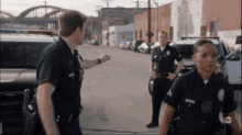 a group of police officers standing on a street with abc written on the bottom left