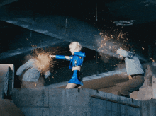 a woman in a blue costume is fighting a man in a white shirt