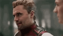 a man in a superhero suit is talking to another man .