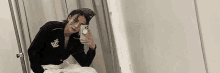 a woman in a sailor suit is taking a selfie in a bathroom mirror .