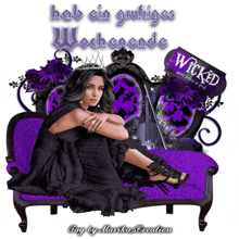 a woman in a black dress sits on a purple couch with a wicked sign behind her