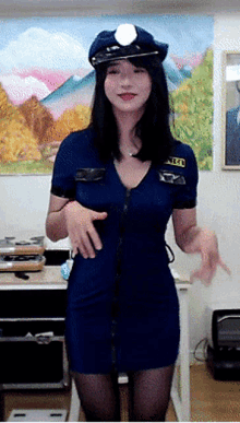 a woman in a police uniform is standing in front of a table .