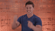 a man in a blue shirt holds his fist in the air