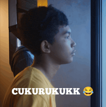 a man in a yellow shirt is looking out a window with the words cucurukukk written above him