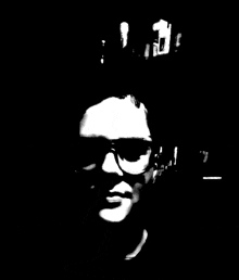 a black and white photo of a person 's face with sunglasses on