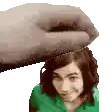 a hand is putting something on a woman 's head