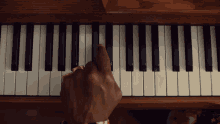 a person is playing a piano with their finger on the keys