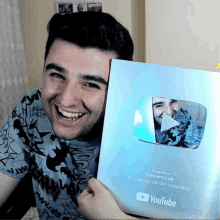 a man is holding a youtube plaque in front of him