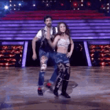 a man and a woman are dancing together on a stage .