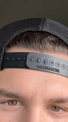 a close up of a man wearing a hat that says richardson on the strap