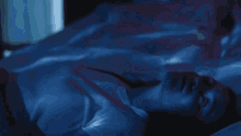 a woman in a white shirt is laying down in the dark