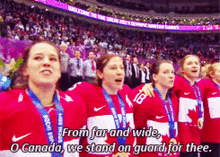 a group of female athletes are standing in front of a crowd and a sign that says welcome to the sochi winter games