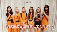 a group of girls standing next to each other in front of a camera with the words everglow written on the bottom