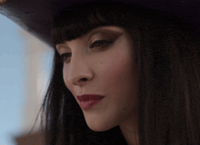 a close up of a woman 's face wearing a purple hat
