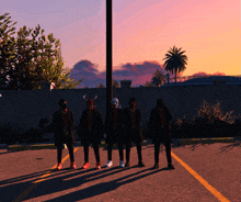 a group of people wearing masks are standing in a parking lot at sunset