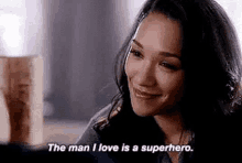 a woman is smiling and saying `` the man i love is a superhero '' .