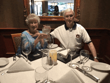 a man wearing an auburn shirt is sitting at a table with his wife