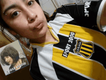 a woman is wearing a black and yellow sport 2000 shirt