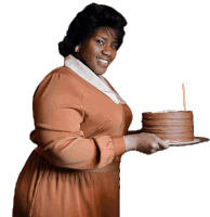 a woman in a brown dress is holding a cake