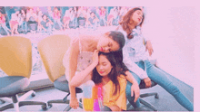 a group of women laying on chairs with a pink background that says ' i love you ' on it