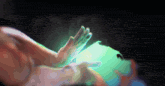 a person 's hand is touching a green light in the dark