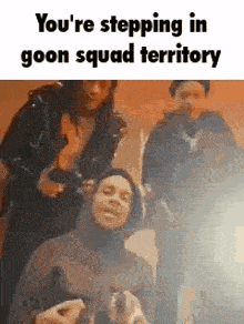 a group of people are standing next to each other and one of them is wearing a hooded jacket .