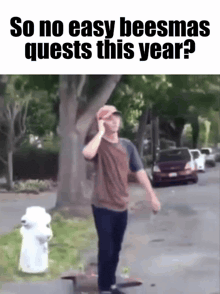 a man talking on a cell phone in front of a fire hydrant with the caption so no easy beesmas quest this year