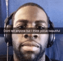 a man wearing headphones with a caption that says dont tell anyone but i think youre beautiful .