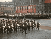 a group of people marching in front of a building with a sign that says ' a ' on it