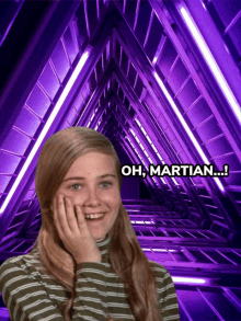 a girl in a striped shirt is smiling in front of a purple tunnel with the words oh martian below her