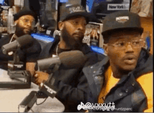 a group of men are sitting in front of microphones and one of them is wearing a hat that says rockwell on it