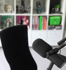 a black microphone is sitting in front of a shelf full of books