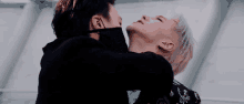 two men wearing masks are kissing each other .