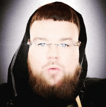 a man with a beard wearing glasses and a hood