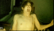 a shirtless man is screaming in front of a screen that says death on it