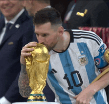 a soccer player with the number 10 on his jersey is kissing a trophy