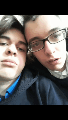 two young men wearing glasses are posing for a photo together